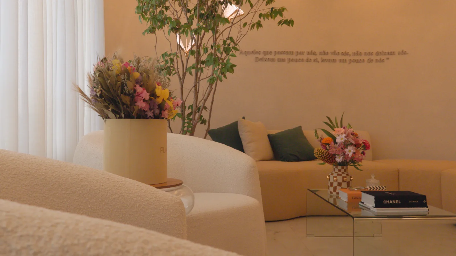 Detalhe da recepção — sofá creme com buquê e jardim interno
