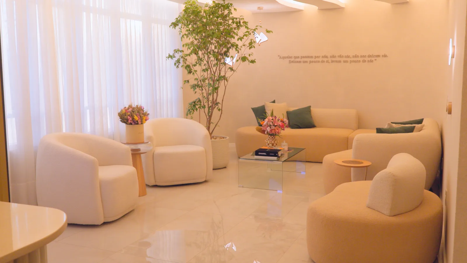 Recepção ampla do Instituto BEEyond com poltronas em boucle e jardim interno